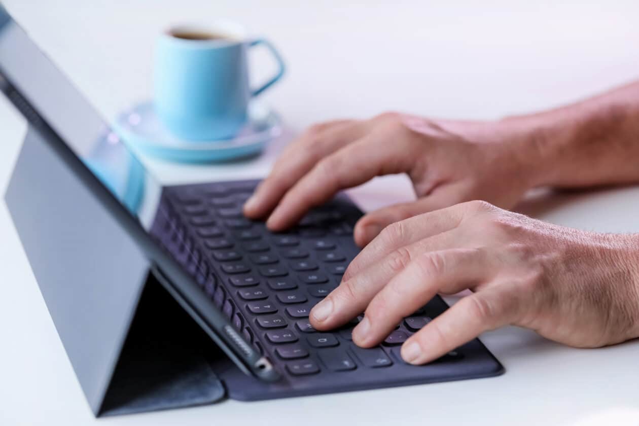 Homem digitando em Smart Keyboard conectado a iPad