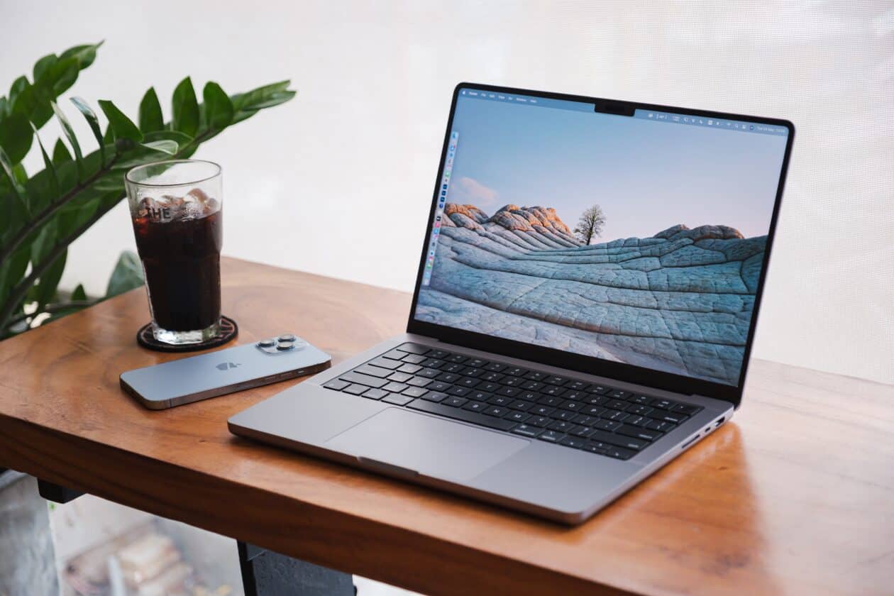 MacBook Pro em uma mesa com refrigerante e iPhone